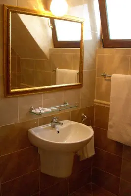 a bathroom with a sink and a mirror and towels at Family hotel Tropicana in Ravda