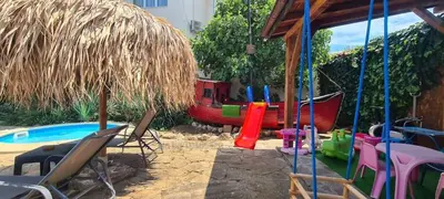 a backyard with a pool and chairs and a playground at Family hotel Tropicana in Ravda