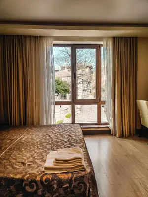 a bedroom with a bed and a large window at Family Hotel Casa del Mare in Sozopol