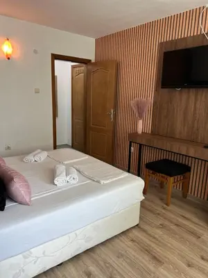 a bedroom with a bed and a desk and a television at Dreams Family Hotel in Nesebar