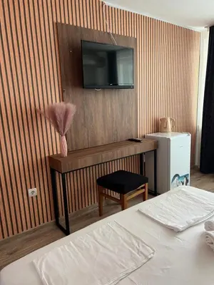 a room with a bed and a television on a wall at Dreams Family Hotel in Nesebar