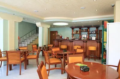 a restaurant with tables and chairs and a bar at Dreams Family Hotel in Nesebar