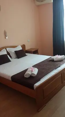 a bed with two pairs of slippers on top of it at Dreams Family Hotel in Nesebar