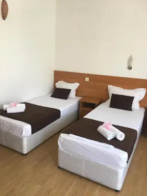 two beds in a hotel room with towels on them at Dreams Family Hotel in Nesebar