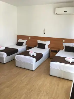 three beds in a room with wooden floors at Dreams Family Hotel in Nesebar