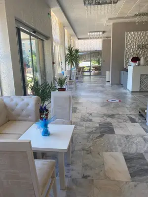 a lobby with couches and tables in a building at Kamenec Hotel in Nesebar