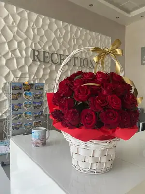 a bouquet of red roses in a basket on a counter at Kamenec Hotel in Nesebar