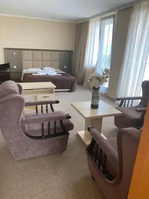 a hotel room with a bed and a living room at Kamenec Hotel in Nesebar