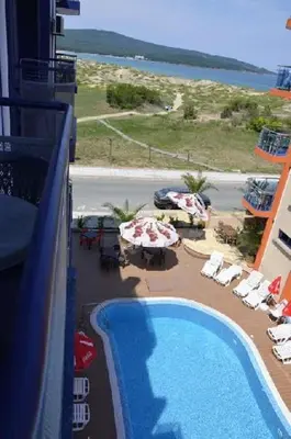 a balcony with a view of a swimming pool and the ocean at Хотел Калипсо Блу in Primorsko