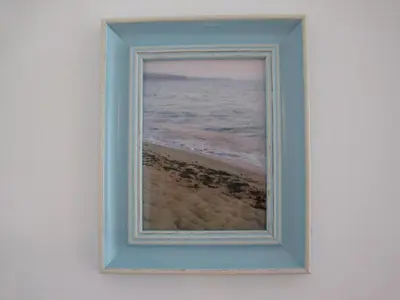 a picture of the beach in a frame on a wall at Apartment Nadejda in Varna City