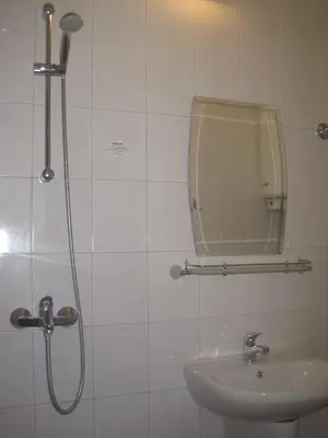 a bathroom with a shower and a sink and a mirror at Apartment Nadejda in Varna City