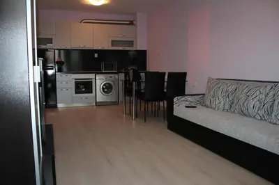 a living room with a couch and a kitchen at Paradise Day in Pomorie