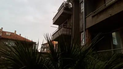 an apartment building with a balcony and plants in front of it at Paradise Corner in Pomorie