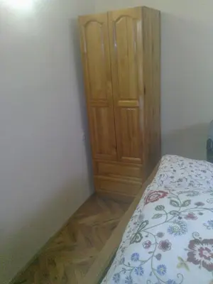 a bedroom with a bed and a wooden cabinet at Paradise Corner in Pomorie