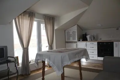 a white kitchen with a table and a window at Paradise Corner in Pomorie