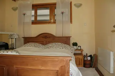 a bedroom with a wooden bed and a window at Paradise Corner in Pomorie