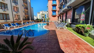 a swimming pool with lounge chairs in a building at апартамент CACAO RESIDENCE in Sunny Beach