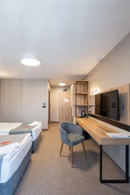 a hotel room with two beds and a desk at Avenue Hotel in Burgas City