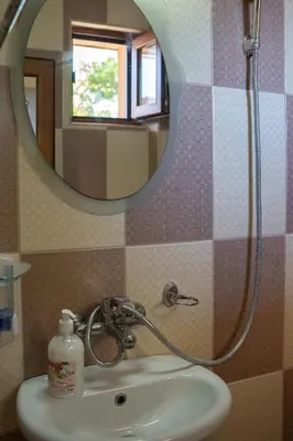 a bathroom with a sink and a mirror at Marianas Guesthouse in Obzor