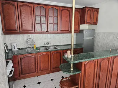 a kitchen with wooden cabinets and a sink at Lazur SeaView Apartment in Pomorie