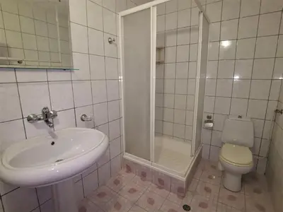 a bathroom with a sink and a shower and a toilet at Lazur SeaView Apartment in Pomorie