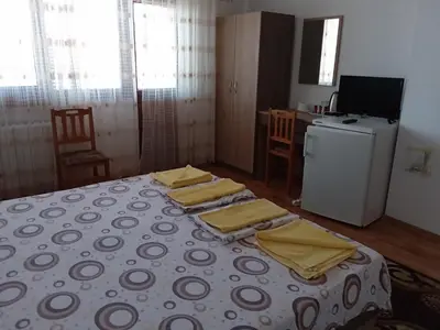 a room with a bed with yellow napkins on it at Стаи за гости Петрови in Primorsko