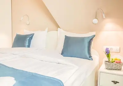 a bedroom with two beds with blue and white pillows at Family Hotel Belle Epoque Beach in Varna City