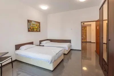 a bedroom with two beds and a table in it at SeaSide Guest Rooms in Burgas City