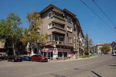 a building with cars parked in front of it on a street at SeaSide Guest Rooms in Burgas City