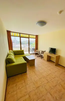 a living room with a green couch and a table at Kaya Apartments in Sunny Beach