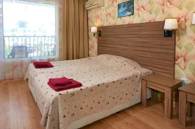 a bedroom with a bed with red towels on it at Hotel Yantra in Sunny Beach