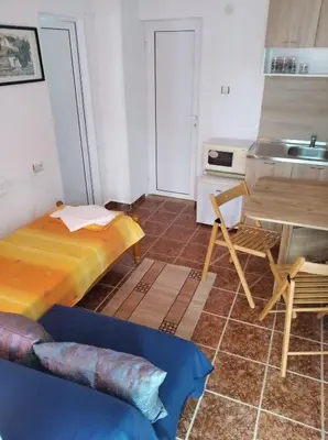 a small kitchen with a bed and a sink at Guesthouse Kolevi in Lozenets