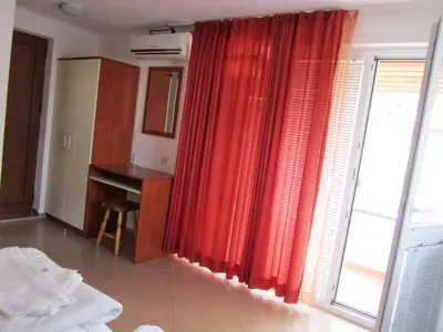 a room with a red curtain and a window at Guesthouse Kolevi in Lozenets