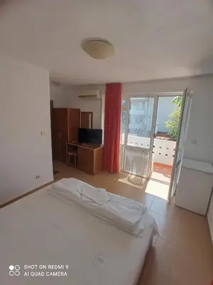 a bedroom with a bed and a sliding glass door at Guesthouse Kolevi in Lozenets