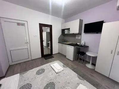 a small white room with a bed and a kitchen at Saraya in Varna City