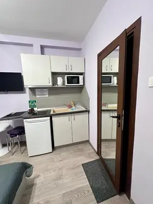 a small kitchen with white cabinets and a table at Saraya in Varna City