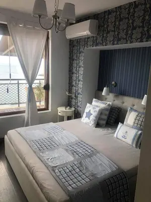 a bedroom with a large bed with a window at Apartment Nadejda in Pomorie