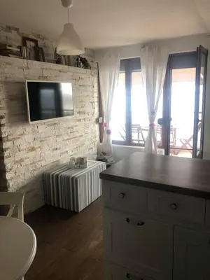 a living room with a tv on a brick wall at Apartment Nadejda in Pomorie