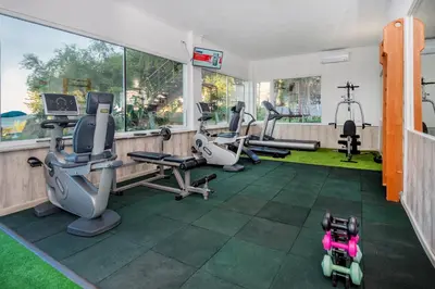 a gym with treadmills and exercise equipment in a room at Hotel Villa List in Sozopol