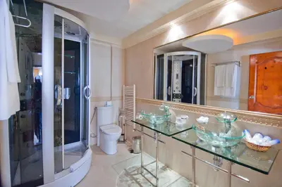 a bathroom with a sink and a toilet and a mirror at Hotel Villa List in Sozopol