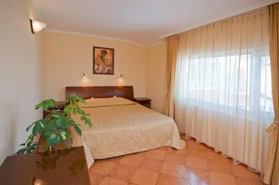 a bedroom with a bed and a large window at Hotel Villa List in Sozopol