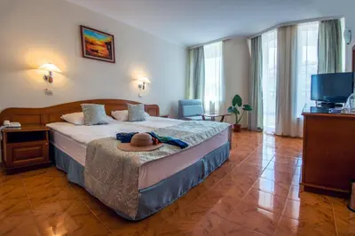 a hotel room with a bed with a hat on it at Hotel Villa List in Sozopol