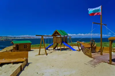 a playground with a slide on the beach at Sozopolis Holiday Village in Sozopol