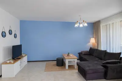 a living room with a couch and a blue wall at Sozopolis Holiday Village in Sozopol