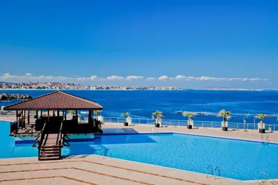 a swimming pool with the ocean in the background at Sozopolis Holiday Village in Sozopol