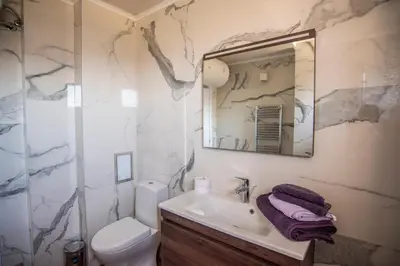 a bathroom with a sink and a toilet and a mirror at Villa Lili in Sozopol