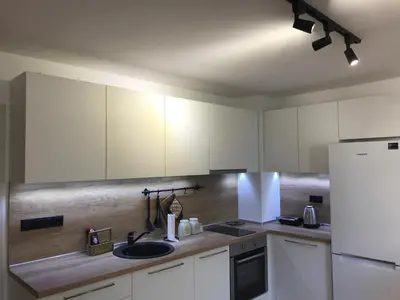 a kitchen with white cabinets and a sink and a refrigerator at Bright, Comfortable and Cozy Apartment in Burgas City