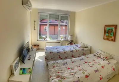 a small bedroom with two beds and a window at Charming Beach Holiday Apartment in Lozenets