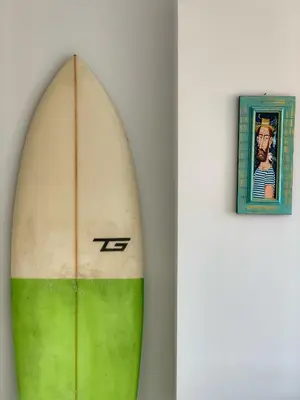 a surfboard leaned up against a wall next to a picture at Charming Beach Holiday Apartment in Lozenets