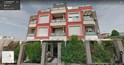 a red building with trees in front of it at Charming Beach Holiday Apartment in Lozenets